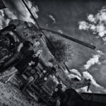 Paar steht Arm in Arm vor einem kaputten Hubschrauber an einem Lost Place