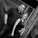 Cooles Paar steht Arm in Arm und sieht in die Kamera